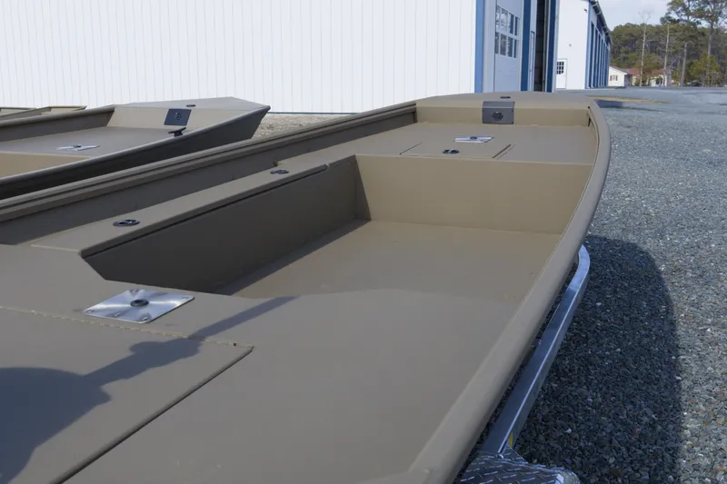Slide: The Image of 2026 G3 Gator Tough 16 DK boat, beige color, parked outside a building. - 7