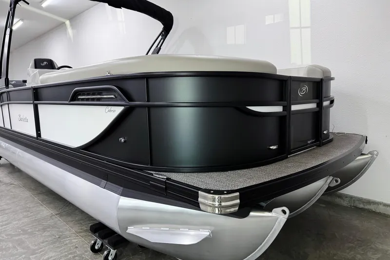 Slide: The Image of 2026 Barletta Cabrio 24M pontoon boat in showroom, featuring sleek black and white design. - 5