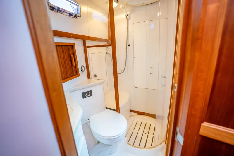 Slide: The Image of 2006 Sabreline 36 Fly yacht bathroom with shower, toilet, and wooden accents. - 102