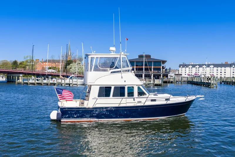 Slide: The Image of 2006 Sabreline 36 Fly yacht cruising in a marina with American flag. - 108