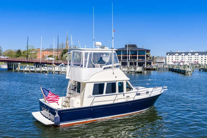 Slide: The Image of 2006 Sabreline 36 Fly yacht docked in a marina with American flag. - 110