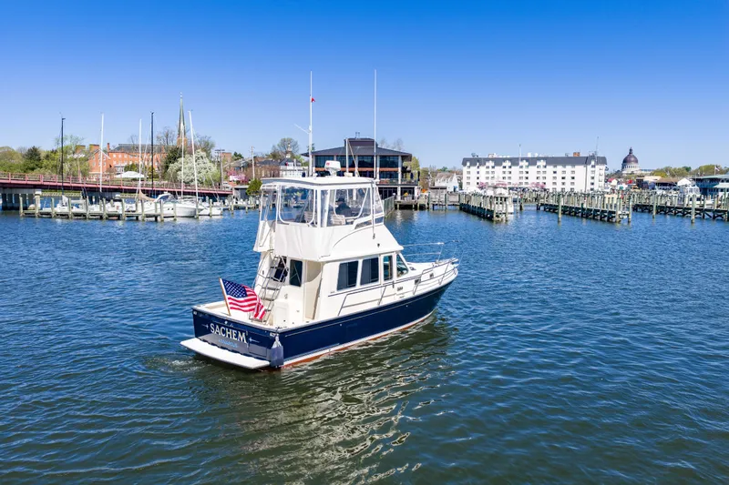 Slide: The Image of 2006 Sabreline 36 Fly yacht cruising in a scenic marina with clear blue skies. - 112