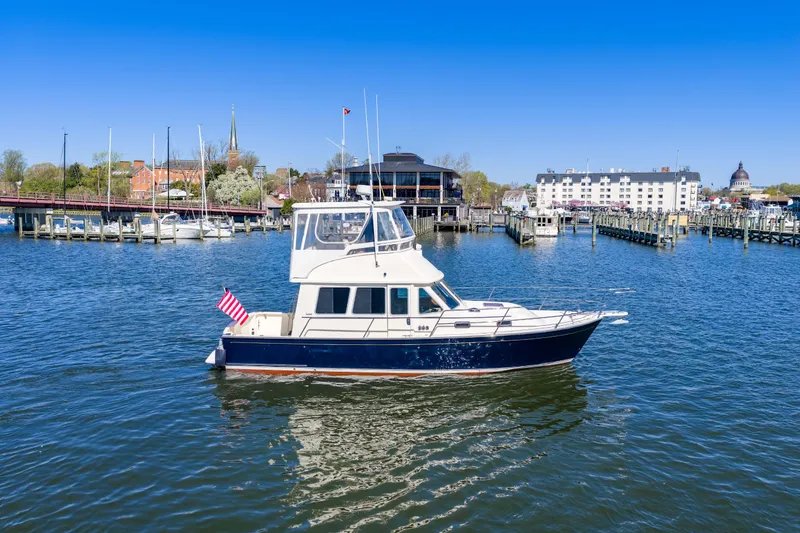Slide: The Image of 2006 Sabreline 36 Fly yacht cruising in a scenic harbor with clear blue skies. - 114