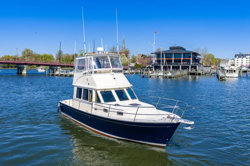 Slide: The Image of 2006 Sabreline 36 Fly yacht on a scenic waterfront with clear blue skies. - 115
