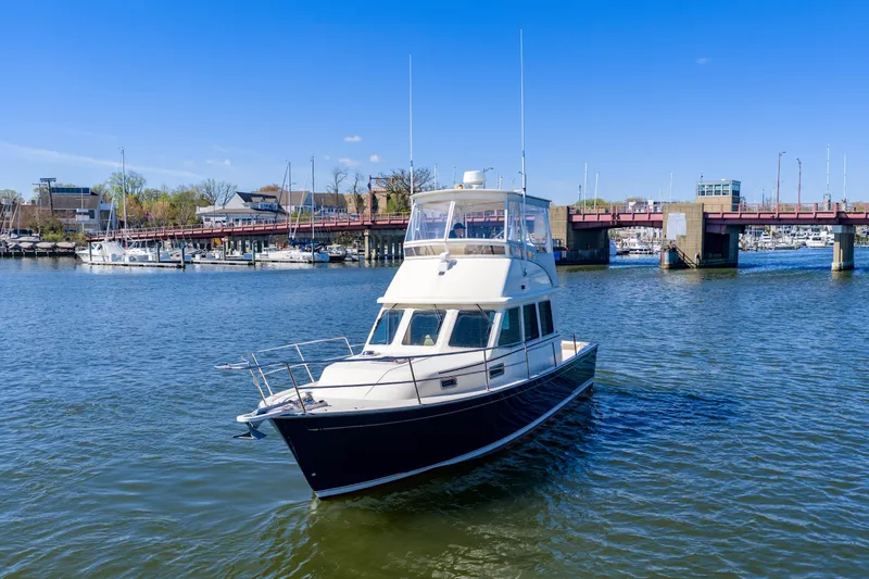 Slide: The Image of 2006 Sabreline 36 Fly yacht cruising near a marina and bridge on a sunny day. - 117