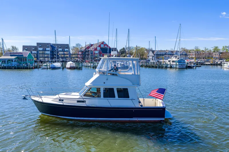 Slide: The Image of 2006 Sabreline 36 Fly yacht cruising in a marina with American flag. - 118