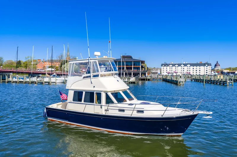 Slide: The Image of 2006 Sabreline 36 Fly yacht cruising in a scenic marina with clear blue skies. - 122