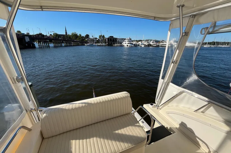 Slide: The Image of 2006 Sabre 36 Flybridge Sedan interior with marina view, featuring comfortable seating and clear skies. - 14