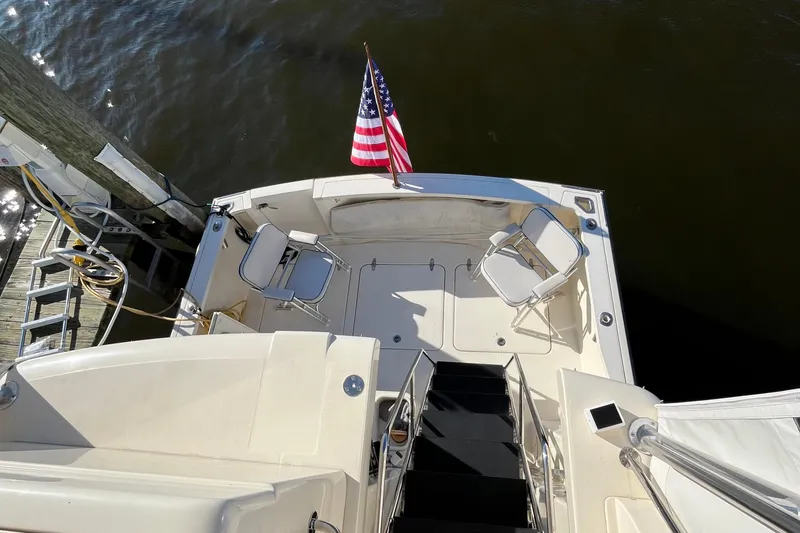 Slide: The Image of 2006 Sabre 36 Flybridge Sedan boat deck with chairs and American flag. - 15
