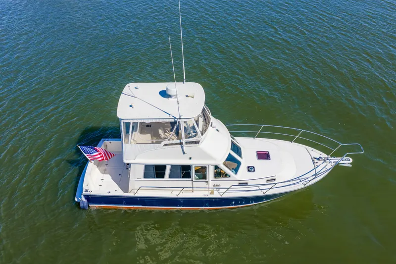 Slide: The Image of 2006 Sabreline 36 Fly yacht on calm water with American flag. - 53