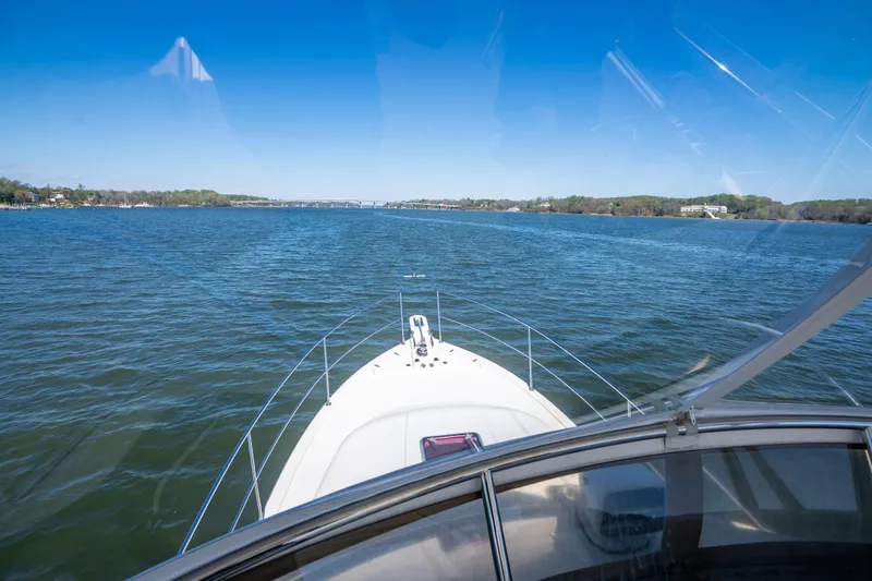 Slide: The Image of View from 2006 Sabreline 36 Fly boat navigating a serene blue lake under clear skies. - 56