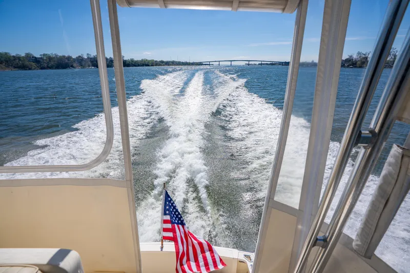 Slide: The Image of 2006 Sabreline 36 Fly cruising on water, American flag visible, scenic view. - 60