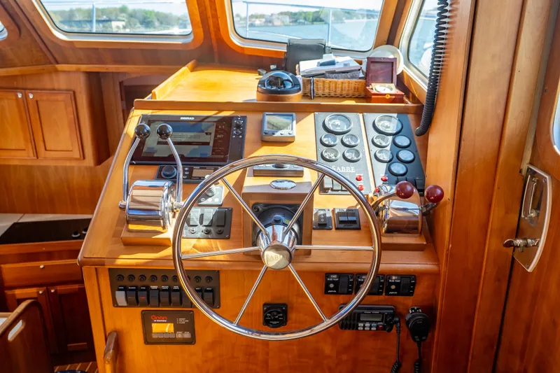 Slide: The Image of Helm of 2006 Sabreline 36 Fly yacht with wooden dashboard and navigation controls. - 79