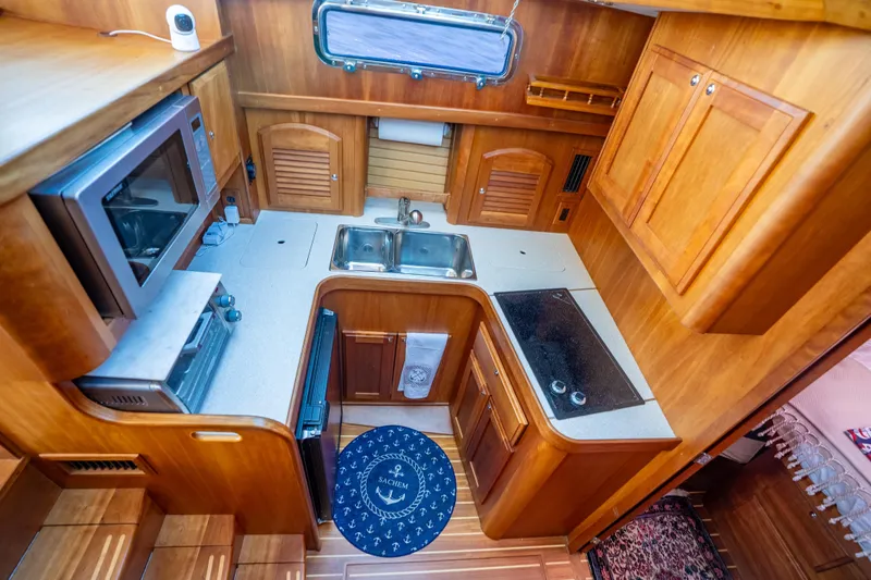 Slide: The Image of Compact kitchen in 2006 Sabreline 36 Fly yacht with wood cabinetry and modern appliances. - 92