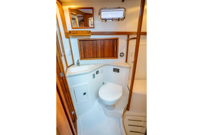 Slide: The Image of 2006 Sabreline 36 Fly yacht bathroom with wooden accents and compact design. - 99