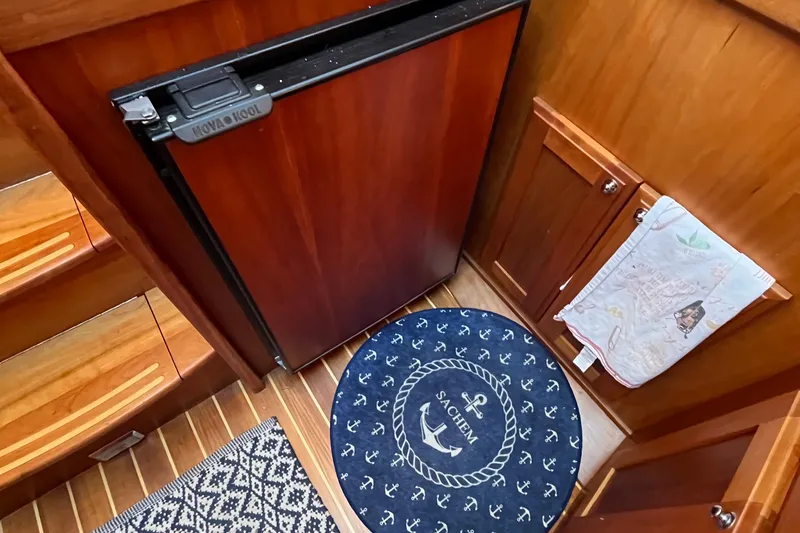 Slide: The Image of Interior of 2006 Sabre 36 Flybridge Sedan with wood finish and nautical-themed rug. - 29