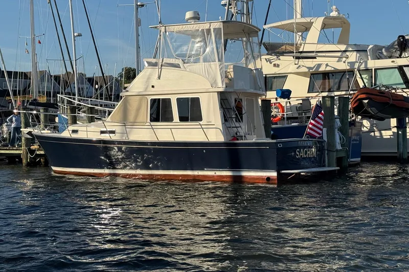 Slide: The Image of 2006 Sabre 36 Flybridge Sedan docked at marina, displaying American flag. - 3