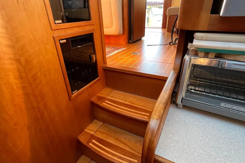 Slide: The Image of Interior of 2006 Sabre 36 Flybridge Sedan with wooden steps and compact kitchen area. - 30