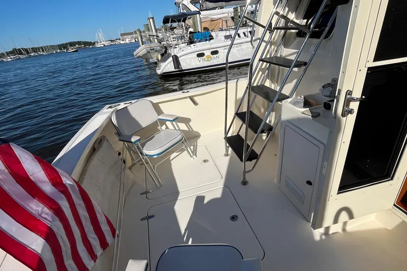 Slide: The Image of 2006 Sabre 36 Flybridge Sedan boat deck with chairs and American flag. - 6