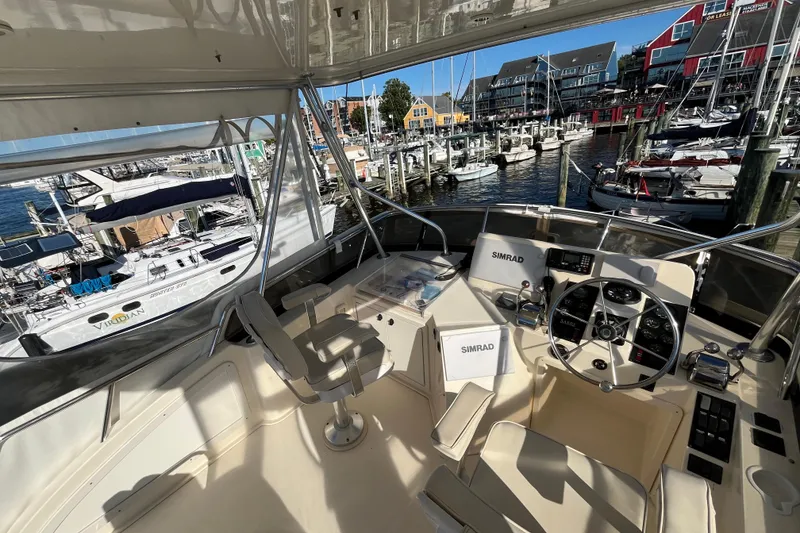 Slide: The Image of 2006 Sabre 36 Flybridge Sedan helm with marina view, featuring Simrad navigation equipment. - 9