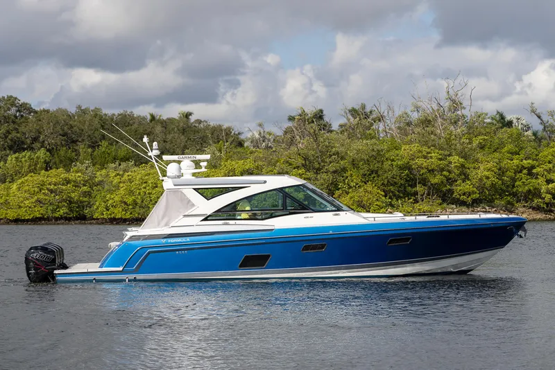 The Image of 2019 Formula 430 Super Sport Crossover boat on calm water, lush greenery in background. - 0