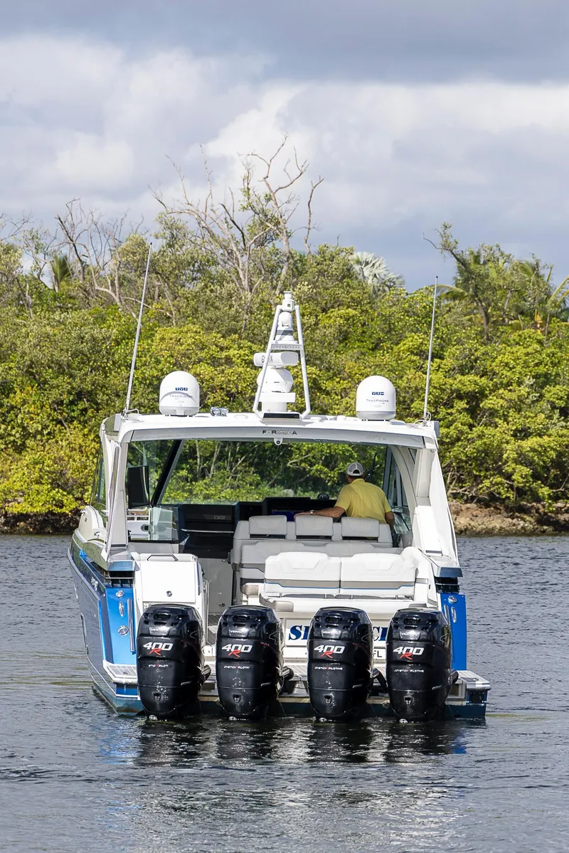 Slide: The Image of 2019 Formula 430 Super Sport Crossover boat with four outboard engines on a calm waterway. - 4
