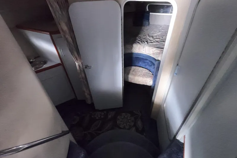 Slide: The Image of Interior of 1989 Searay 30 Sedan Bridge, featuring cozy cabin and compact sink area. - 10