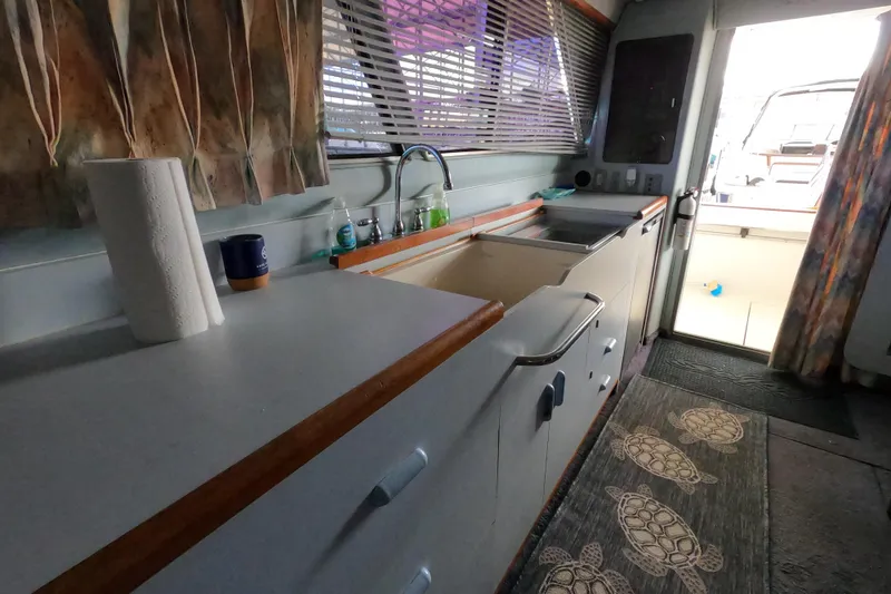 Slide: The Image of Interior of 1989 Searay 30 Sedan Bridge boat kitchen with sink and counter. - 16