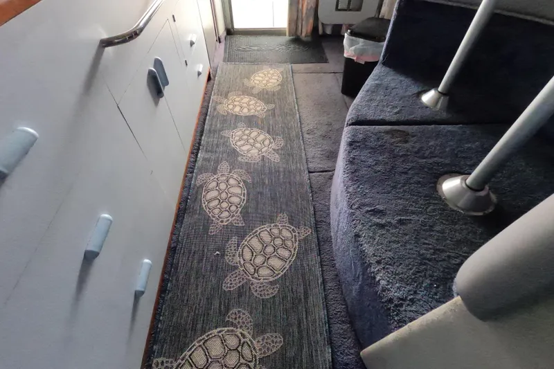 Slide: The Image of Interior of 1989 Searay 30 Sedan Bridge with turtle-patterned carpet runner. - 17