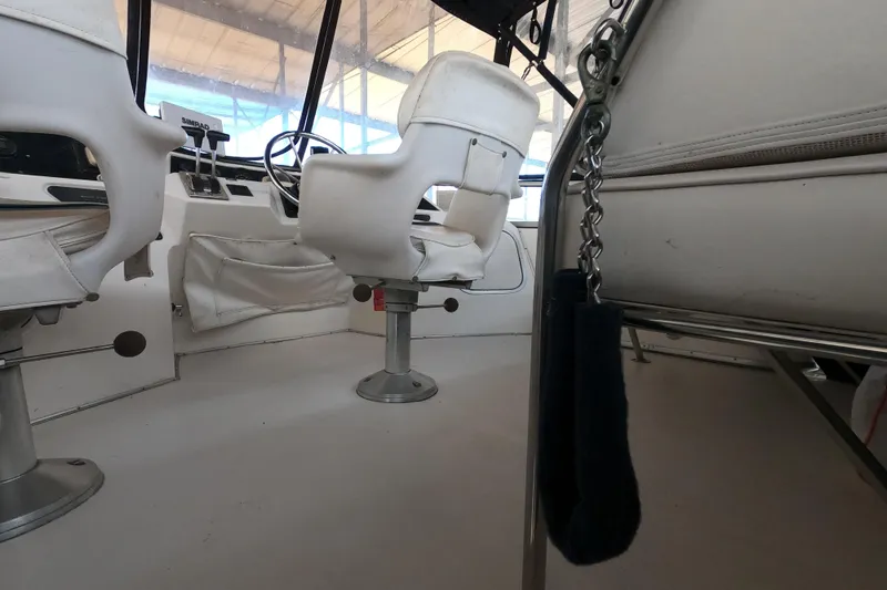 Slide: The Image of Interior of 1989 Searay 30 Sedan Bridge with white captain chairs and steering wheel. - 23