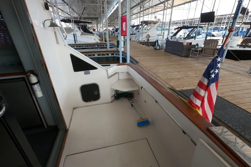 Slide: The Image of 1989 Searay 30 Sedan Bridge boat docked, featuring American flag and marina setting. - 25