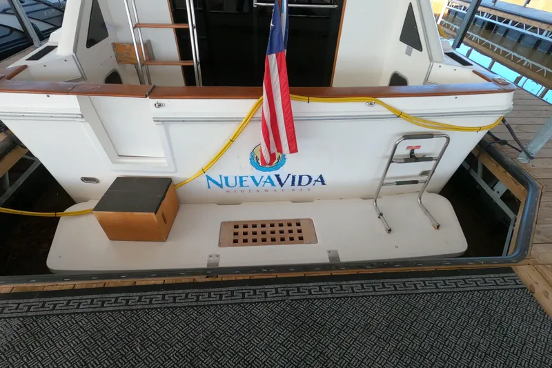 Slide: The Image of 1989 Searay 30 Sedan Bridge boat with "Nueva Vida" name and American flag. - 26