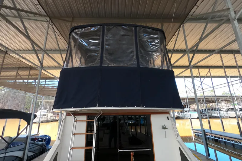 Slide: The Image of 1989 Searay 30 Sedan Bridge under covered dock, featuring enclosed upper deck. - 27