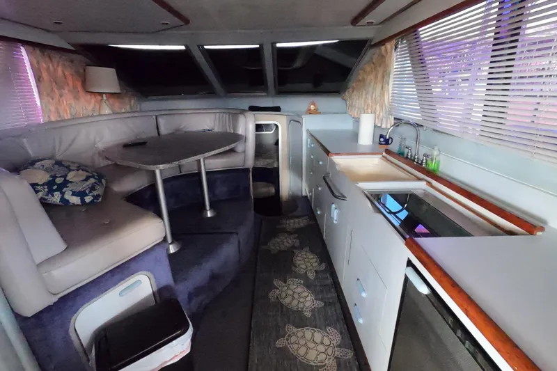 Slide: The Image of 1989 Searay 30 Sedan Bridge interior with kitchen and dining area. - 6