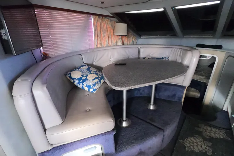 Slide: The Image of 1989 Searay 30 Sedan Bridge interior with curved seating and table. - 8