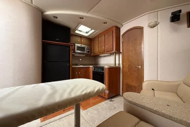 Slide: The Image of Interior of 2006 Rinker Fiesta Vee 410 yacht with kitchenette and seating area. - 14