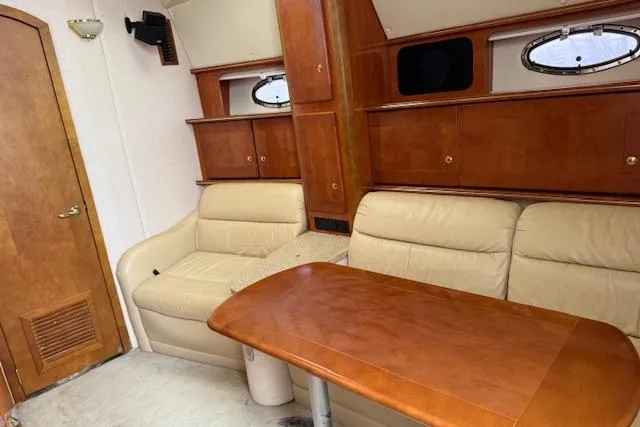 Slide: The Image of 2006 Rinker Fiesta Vee 410 interior with beige seating and wooden table. - 19