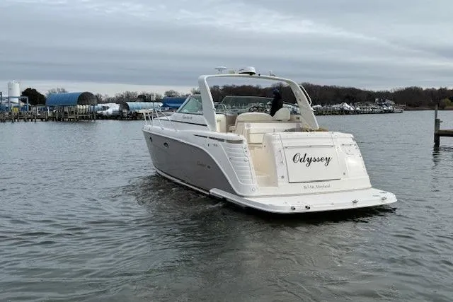 Slide: The Image of 2006 Rinker Fiesta Vee 410 boat named "Odyssey" on calm water. - 2