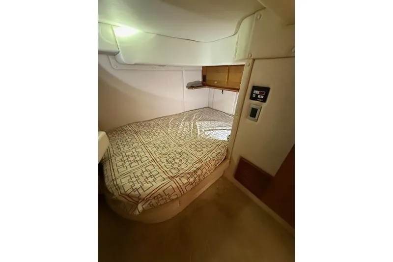 Slide: The Image of 2006 Rinker Fiesta Vee 410 cabin interior with bed and storage shelves. - 20