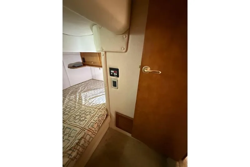 Slide: The Image of Interior cabin of 2006 Rinker Fiesta Vee 410 boat with bed and wooden door. - 21