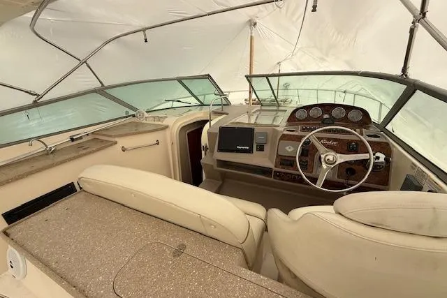 Slide: The Image of 2006 Rinker Fiesta Vee 410 boat interior with steering wheel and dashboard under cover. - 24