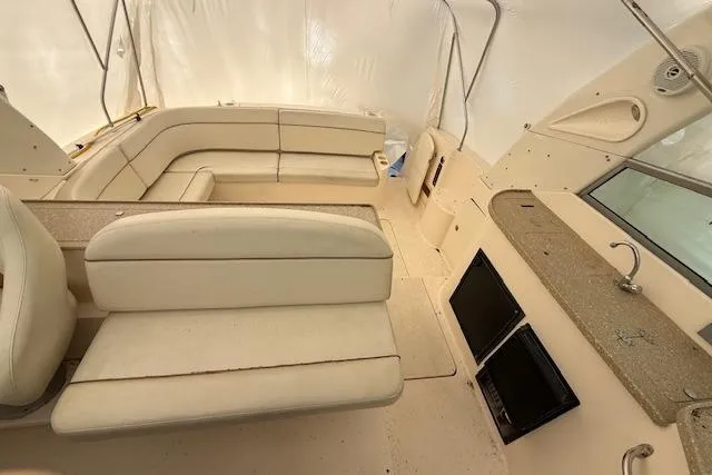 Slide: The Image of 2006 Rinker Fiesta Vee 410 interior with beige seating and kitchenette area. - 33