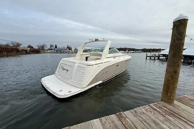 Slide: The Image of 2006 Rinker Fiesta Vee 410 yacht docked on calm water under cloudy skies. - 6