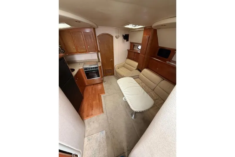 Slide: The Image of 2006 Rinker Fiesta Vee 410 interior with kitchen, seating area, and wooden cabinetry. - 8