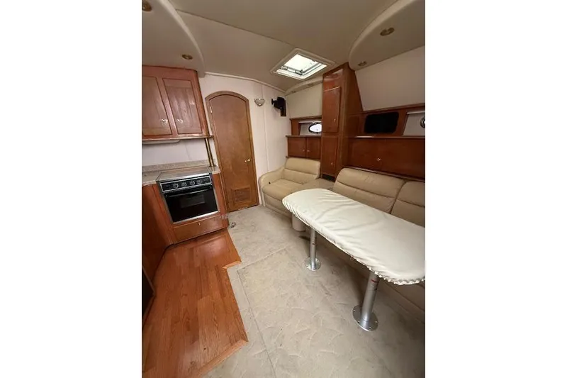 Slide: The Image of 2006 Rinker Fiesta Vee 410 interior with kitchen, seating, and table. - 9