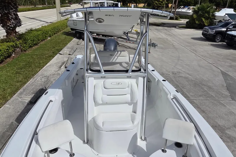 Slide: The Image of 2017 Sea Hunt Ultra 225 boat with seating and T-top in a parking area. - 10