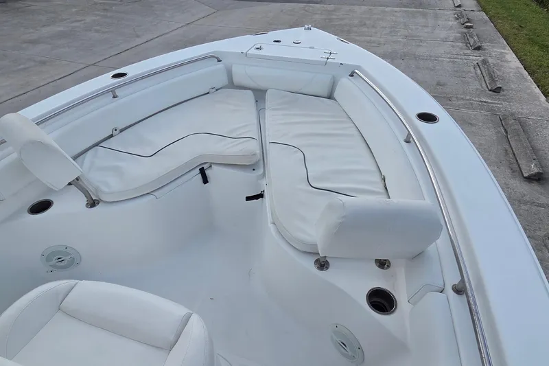 Slide: The Image of 2017 Sea Hunt Ultra 225 boat interior with white cushioned seating and stainless steel railings. - 14
