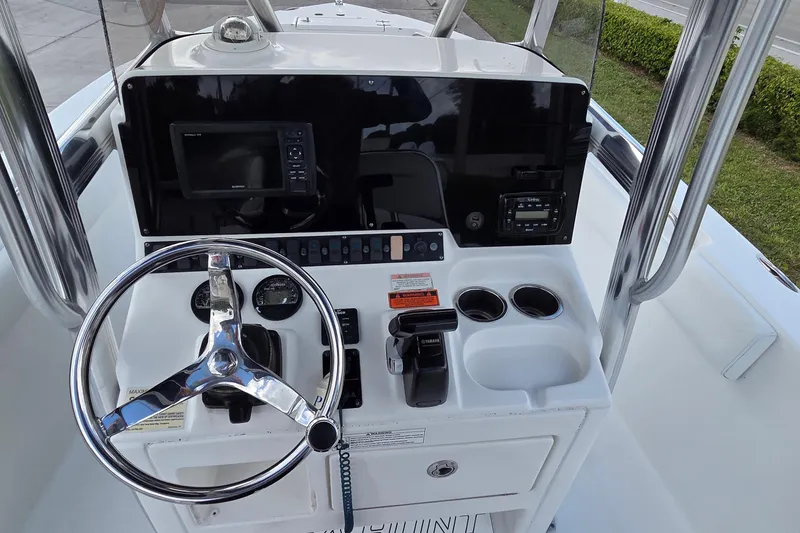 Slide: The Image of 2017 Sea Hunt Ultra 225 boat console with steering wheel, controls, and navigation equipment. - 15