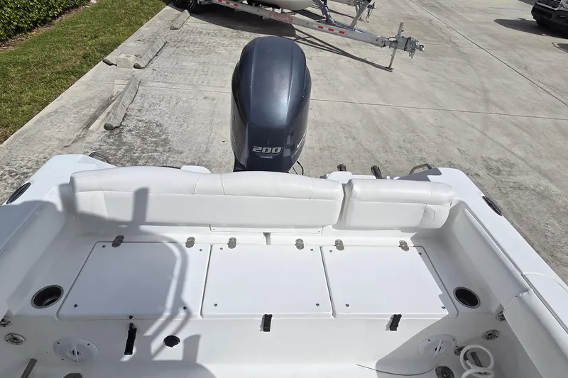 Slide: The Image of 2017 Sea Hunt Ultra 225 boat with Yamaha 200 engine, white seating, and storage compartments. - 17