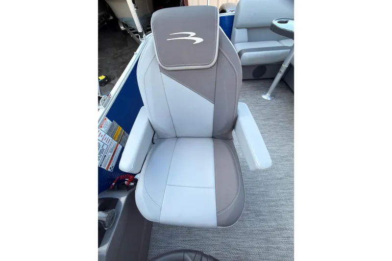 Slide: The Image of 2024 Bennington SVL boat seat with gray and white upholstery, featuring armrests and logo. - 11